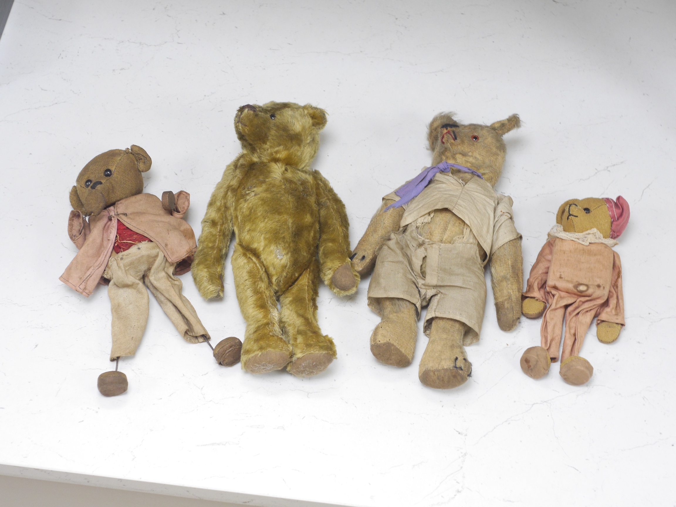 An early 20th century German hump backed plush teddy bear and three others, German teddy 30cm high. Condition - the German teddy has a short split on the back seam and glue on the front leg that needs removing and plush